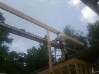 Carpenter setting a ridge beam over a new addition frame — Ice Dam Removal by Roofing Brothers in Liberty
